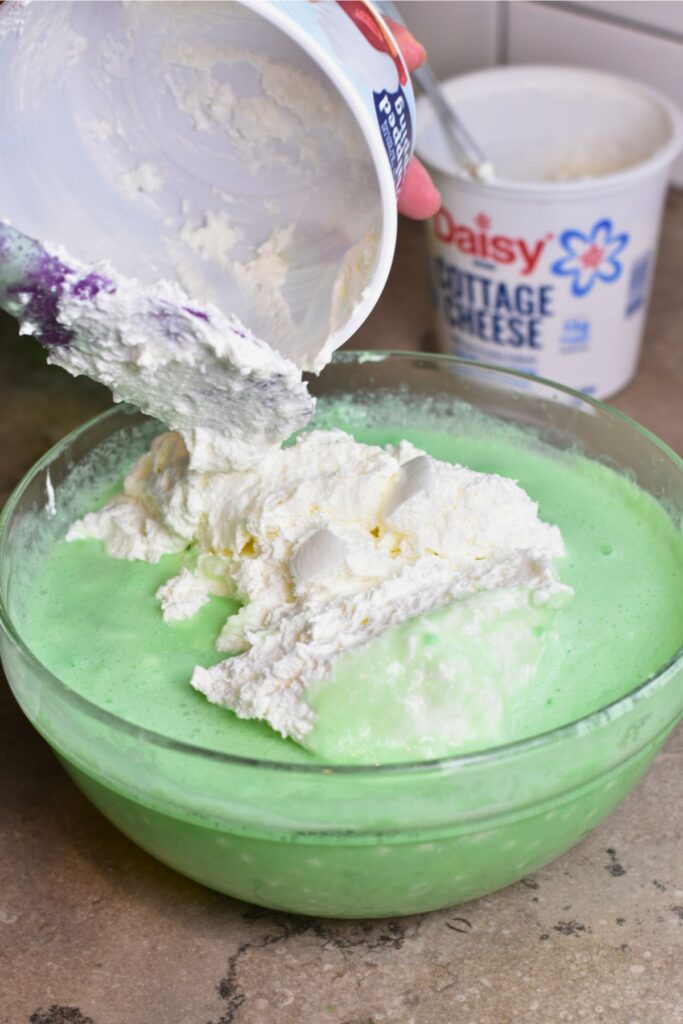 adding-the-whipped-topping-into-the-chilled-jello-mixture After refrigerating the mixture, adding the whipped topping and fold it in.