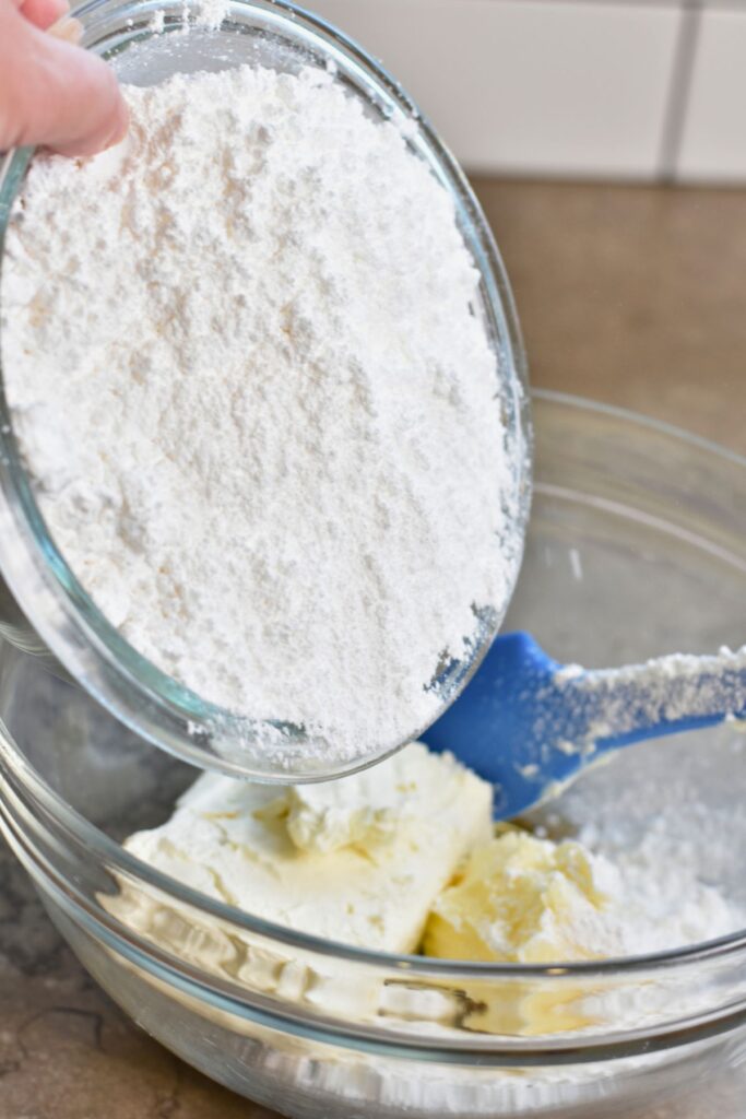 make-the-cream-cheese-frosting Add the powdered sugar to the cream cheese and butter mixture.