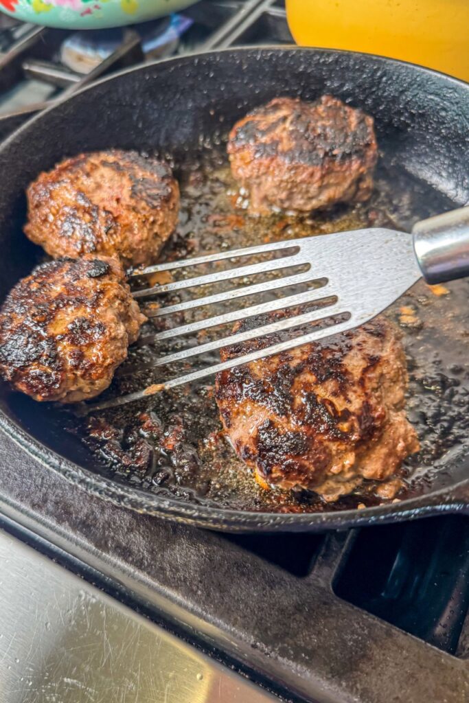 cooking-the-patties-until-dark-brown cooking the burgers in an iron skillet before making the gravy.