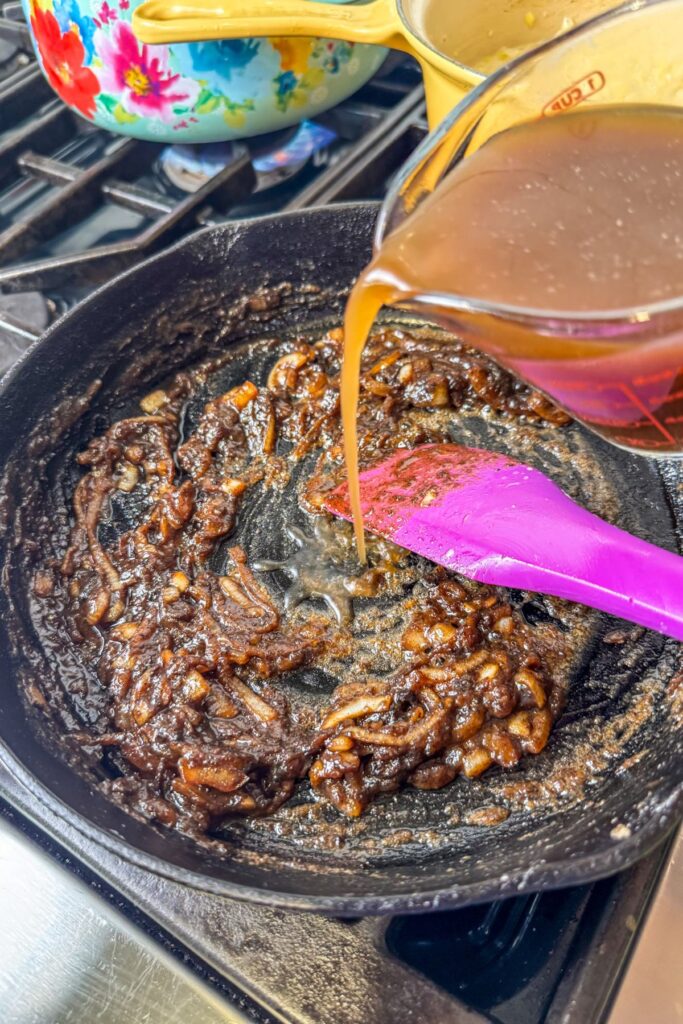 pouring-the-beef-broth-into-the-onion-mixture Adding beef broth to the grilled onion mixture.