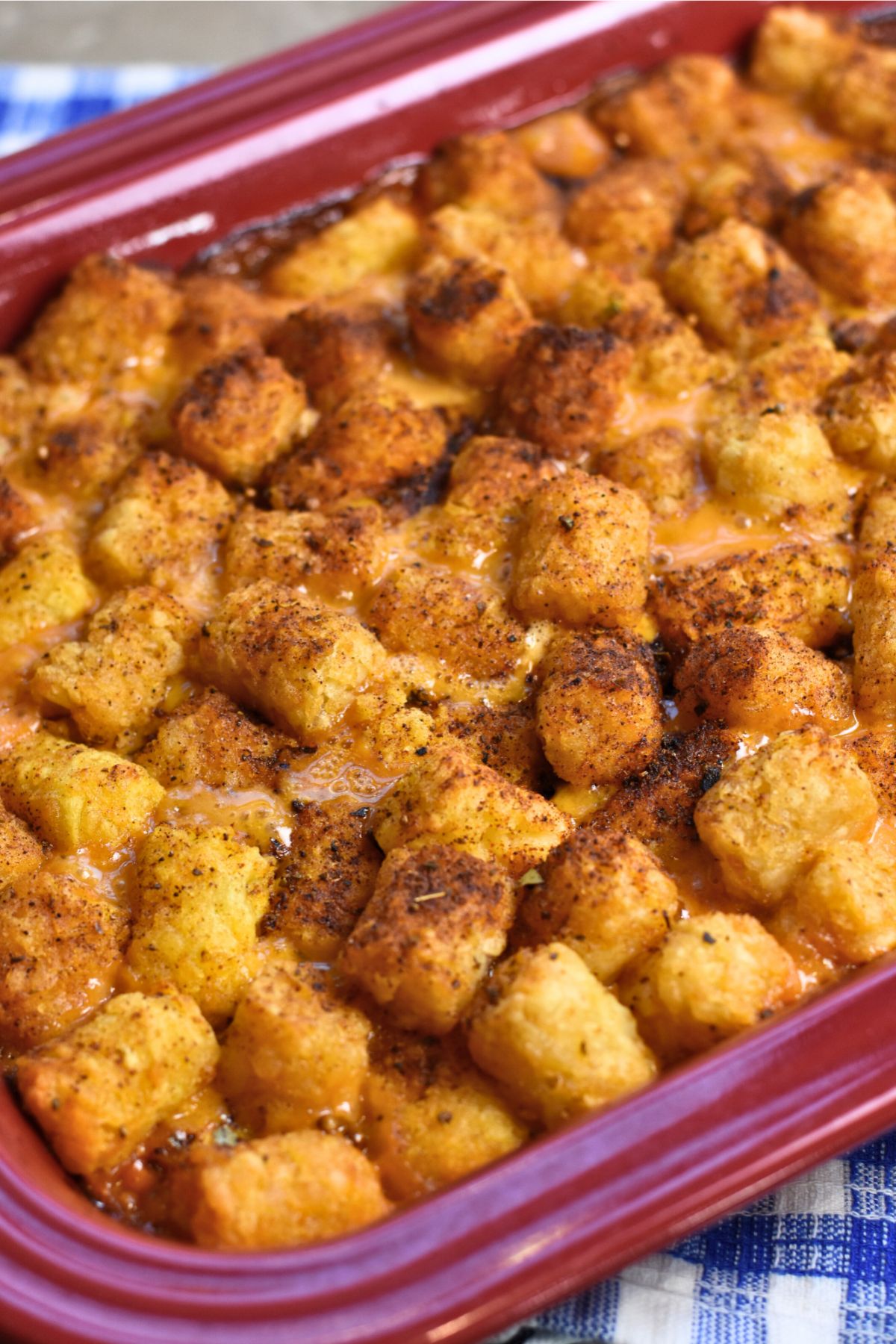 serving-the-crispy-tater-tot-casserole-on-a-grey-plate Casserole dish of ready-to-eat pulled pork tater tot casserole.