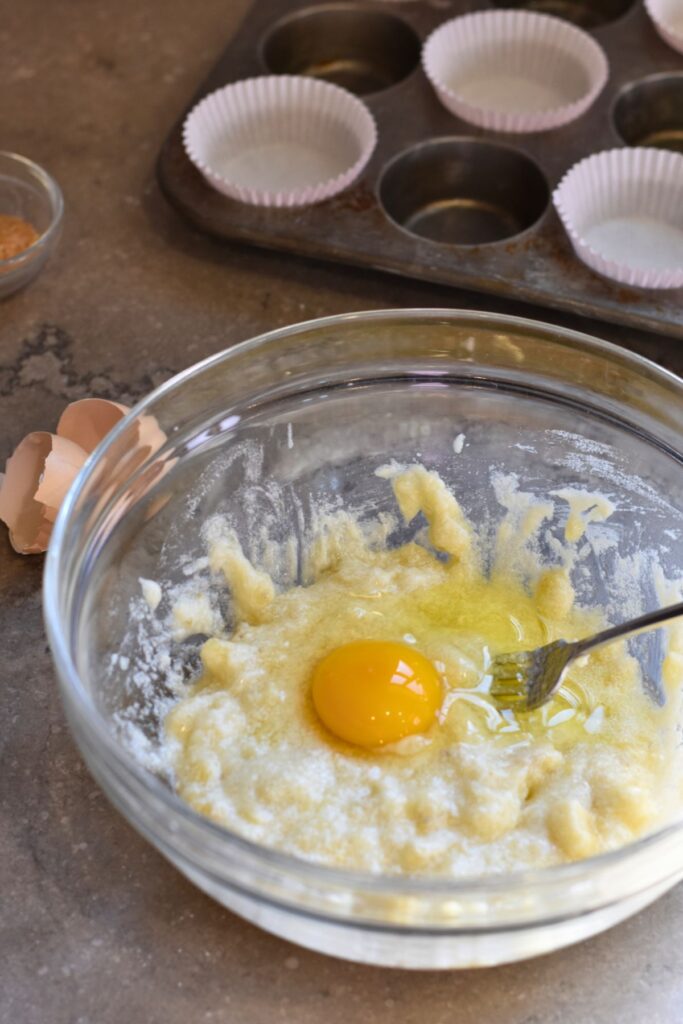 add-the-egg-into-the-banana-muffin-mixture Adding the egg to the banana muffins.