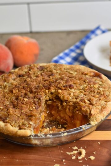 Cutting a slice of the golden brown peach praline pie.