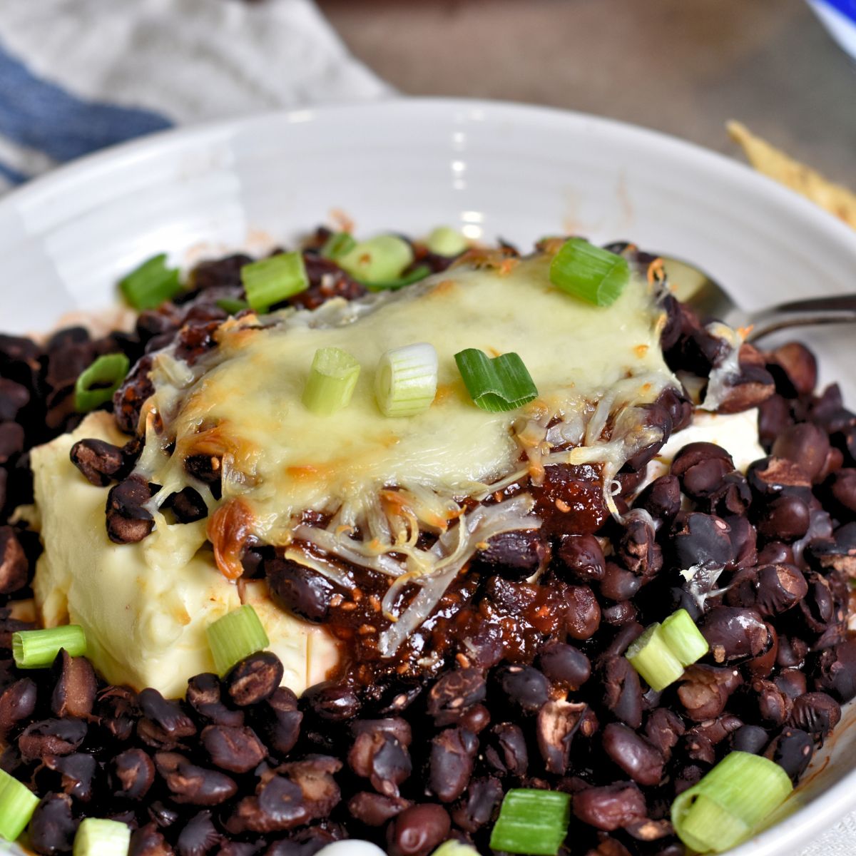 Topping the cream cheese mixture with chopped green onions.
