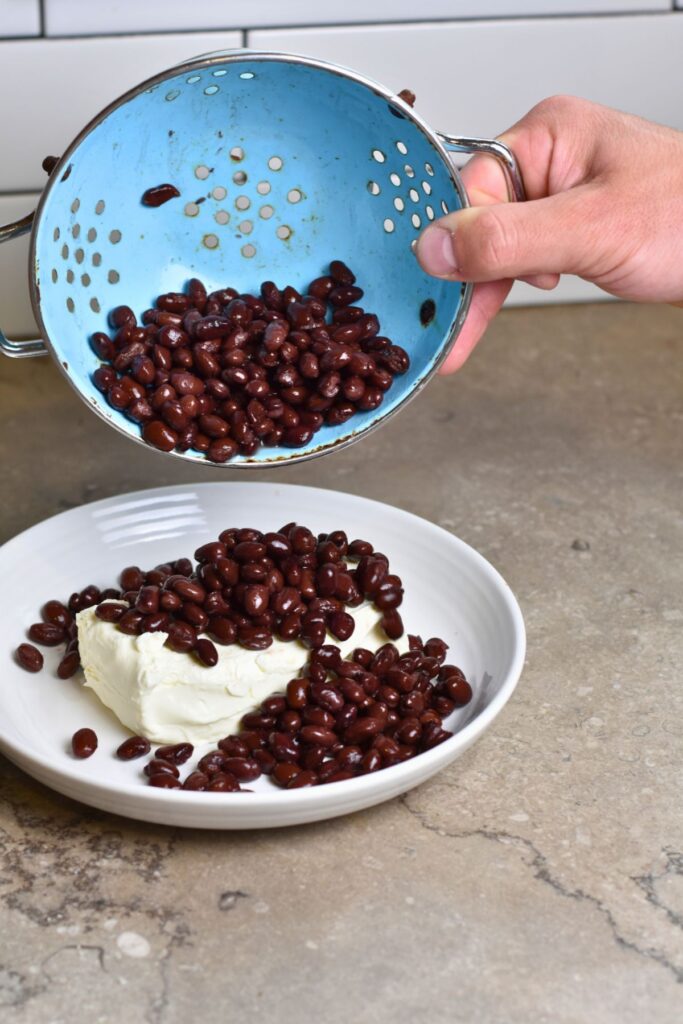 adding the rinsed black beans on top of the cream cheese.