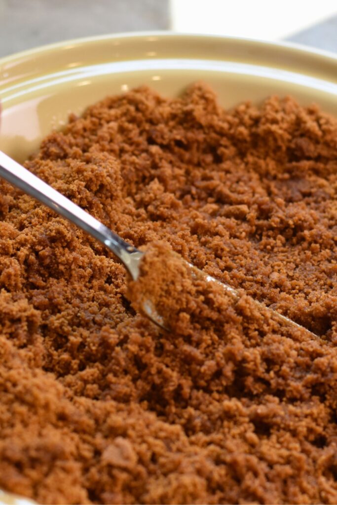 mixing-the-cookie-mixure-in-a-pie-dish mixing the butter and cookie mixture with a fork.