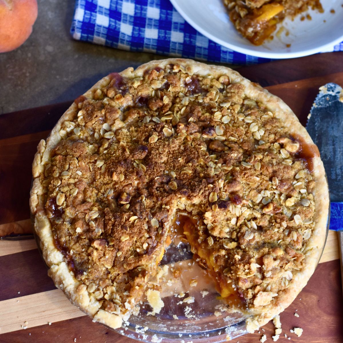 finished peach pie with homemade crumble topping served to guest.