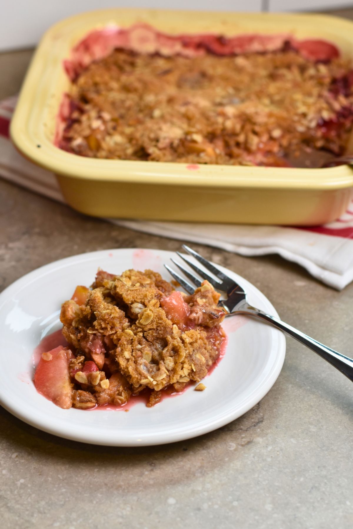 Serving juicy Cherry and Apple crumble served on a white plate.