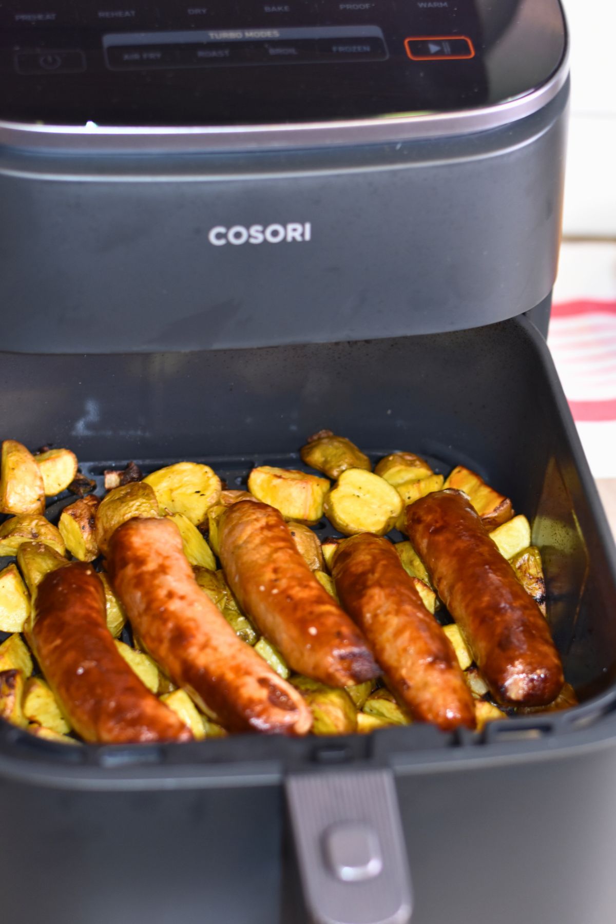 brats-straight-out-of-the-air-frye-served-on-top-of-the-potaotes finished brats in the air fryer.