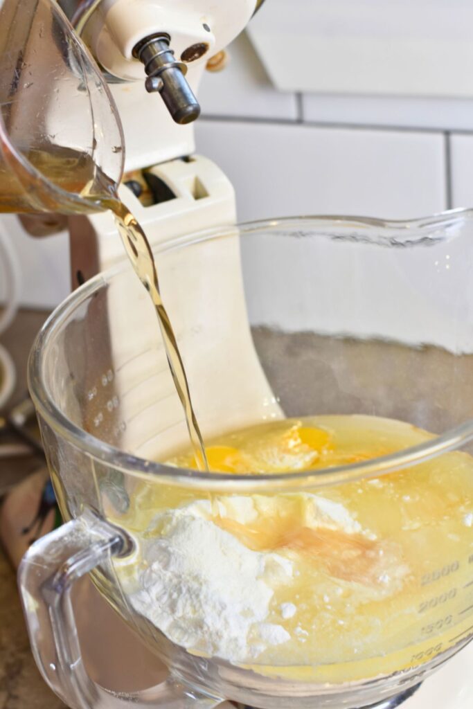 add-all-of-the-ingredients-into-the-mixer adding the oil into the cake mix.