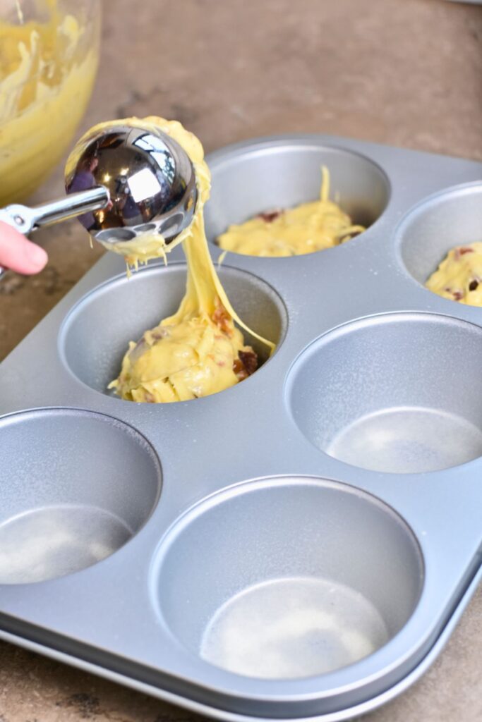 scooping-the-batter-into-the-extra-large-baking-pan scooping the batter into the mini cake pan.