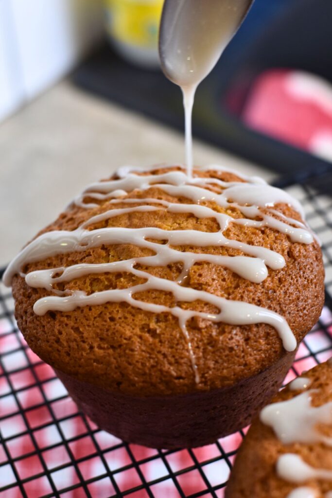 using-a-spoon-to-drizzle-the-icing-onto-the-cake drizzling the icing onto the rumtopf cake.