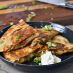 Serving the melty pulled pork quesadilla with sour cream.
