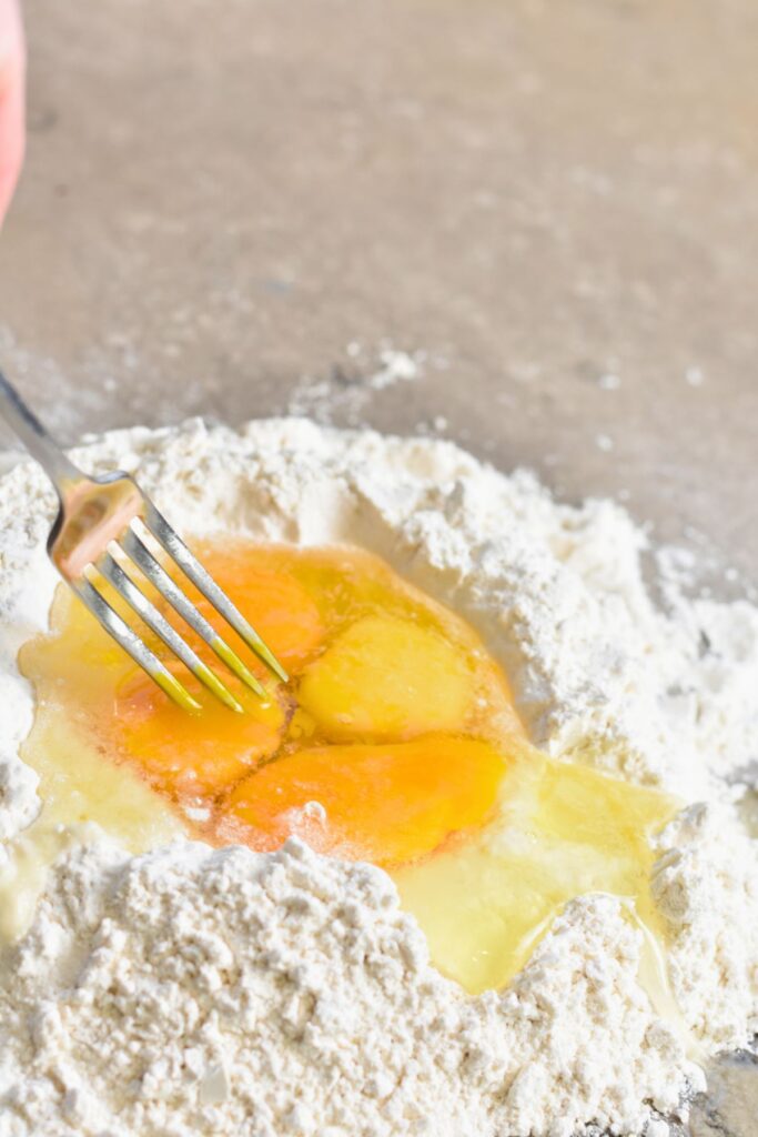 Whisk-the-eggs-into-the-flour-with-a-fork Use a fork to whisk the eggs into the flour.