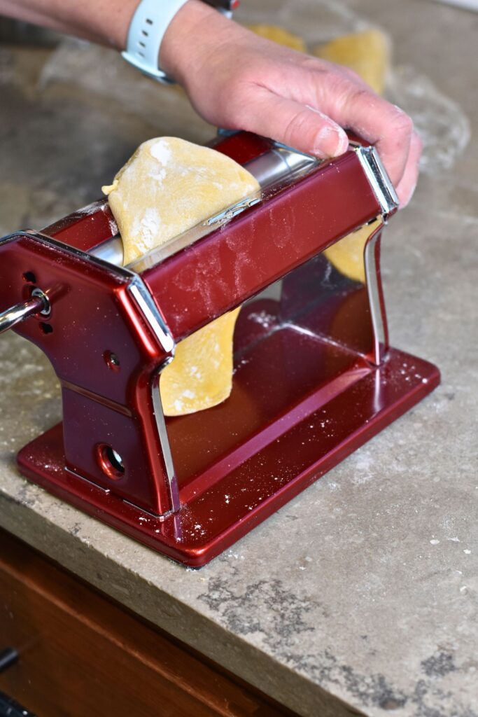 use-the-pasta-machine-to-flatten-the-dough-into-your-desired-thickness Flatten out and roll the dough into sheets.