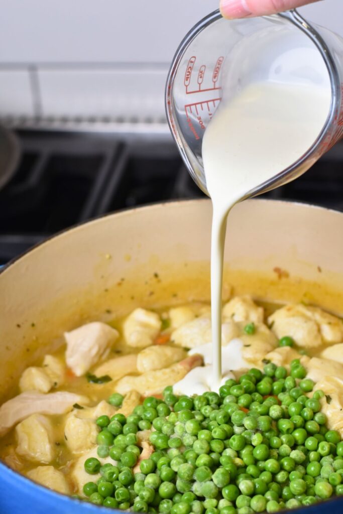 add-in-the-heavy-cream-to-the-buscuit-mixture add the peas and heavy whipping cream into the chicken and vegetable mixture.