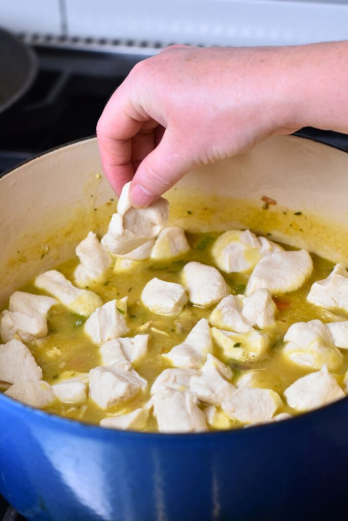 adding-in-the-canned-cut-up-buscuits Dropping the cut up biscuits into the chicken mixture.