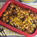 Croissant breakfast casserole served in a red casserole dish.