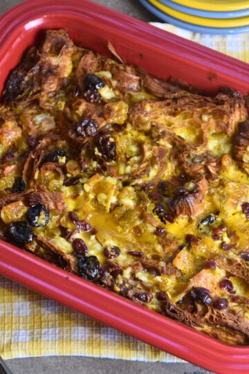Croissant breakfast casserole served in a red casserole dish.