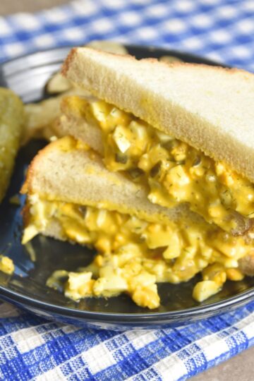 Dill pickle egg salad served on white fluffy bread.