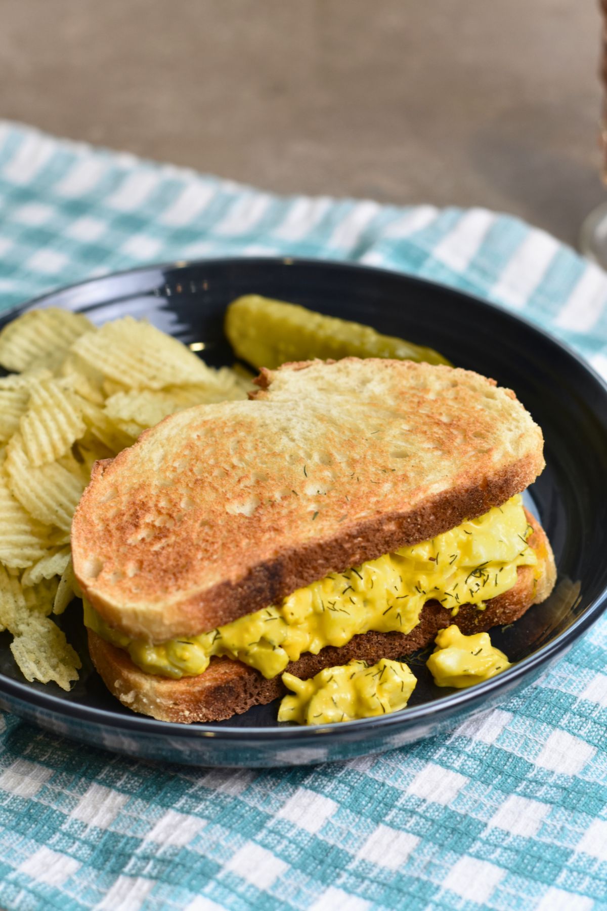 serving-the-dill-pickle-salad-on-crunchy-white-bread Dill pickle egg salad on toasted bread with potato chips.