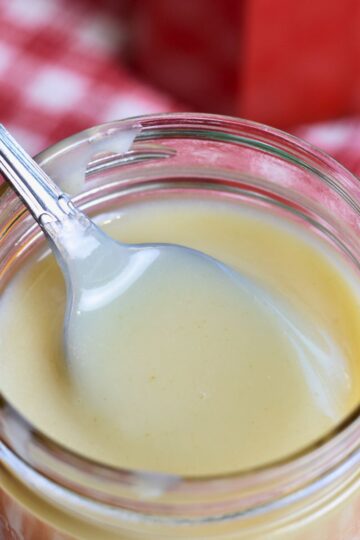 Scooping the syrup out of a jar.