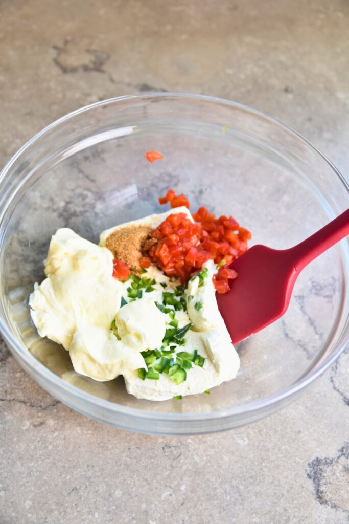 Mixing-the-ingredinets-for-the-cheese-spread Mix all of the ingredients for the pimento cheese in a glass bowl.