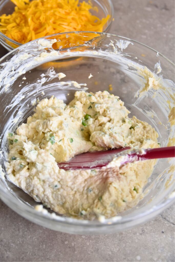 mash-the-cream-cheese-mixture-together-in-a-bowl Mix the cream cheese and onion mixture with a rubber scraper.