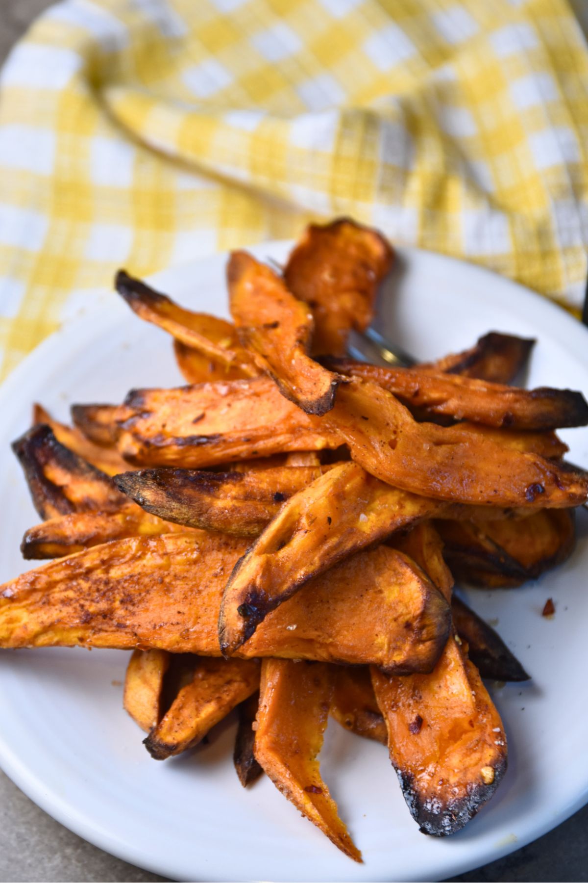 crispy-air-fryer-sweet-potato-wedges Serving sweet potato wedges on a white plate.