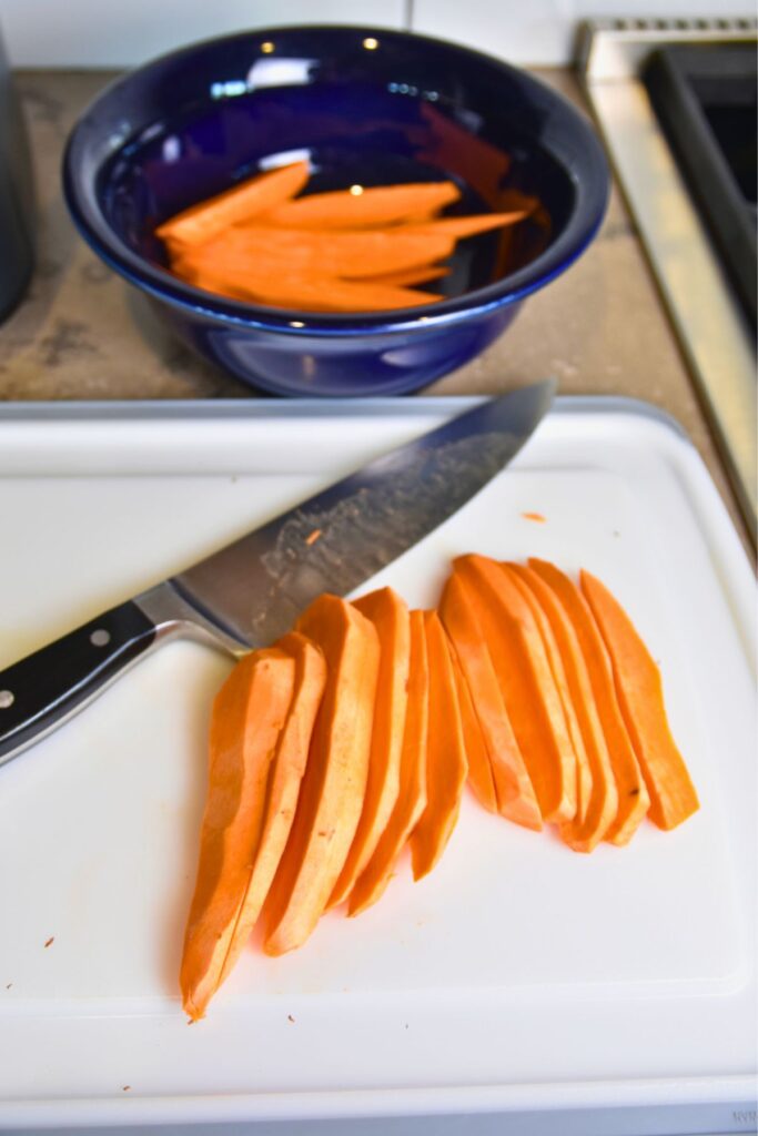 sweet-potato-wedges-sliced-and-ready-to-be-seasoned Slicing sweet potatoes into wedges.
