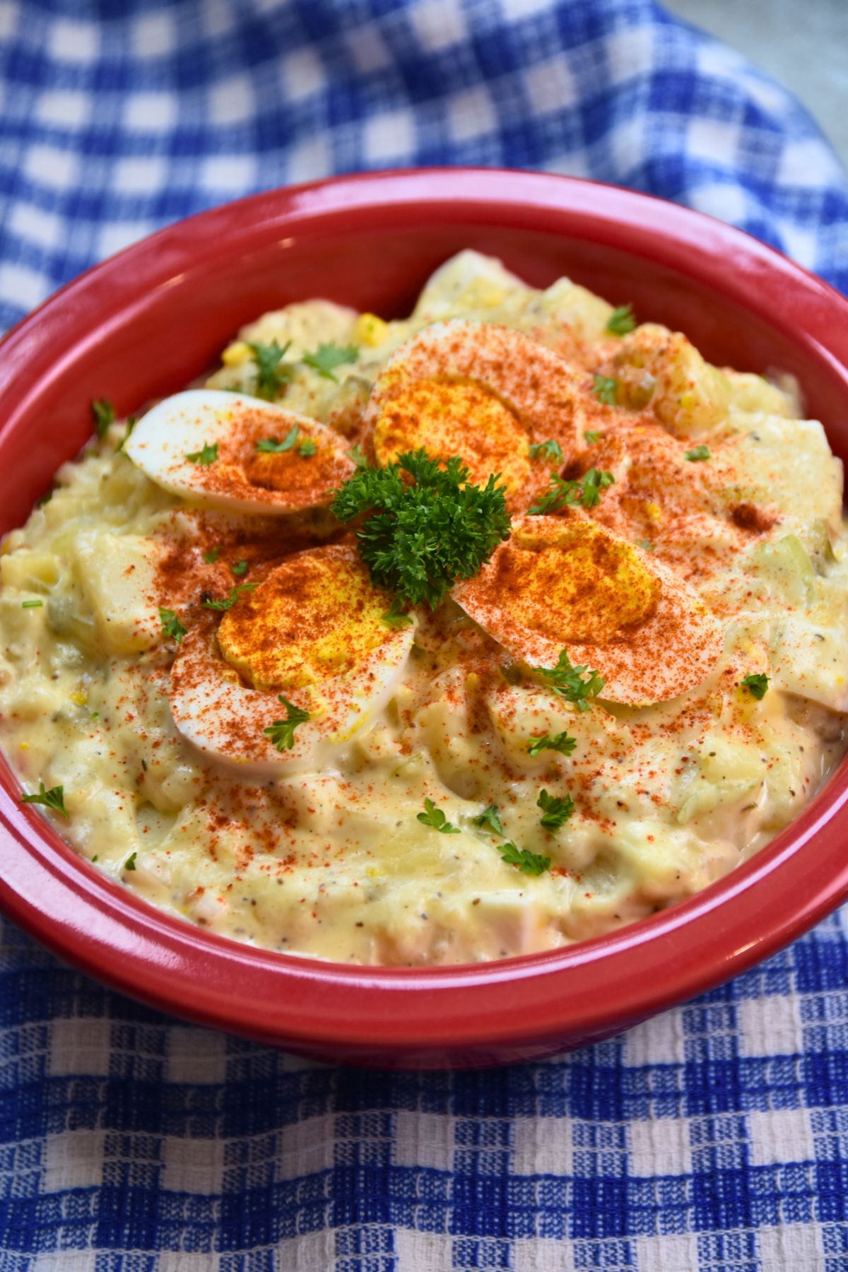 Ready-to-eat-creamy-potato-salad Serving potato salad with a boiled egg on top.