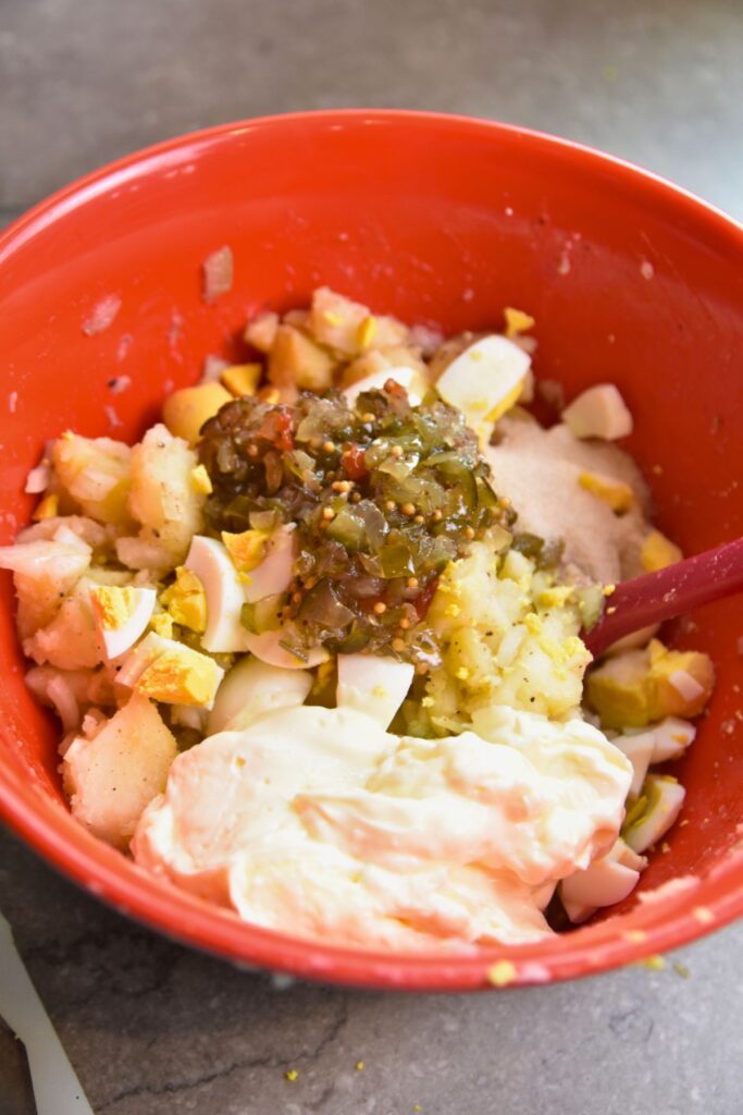 mix-the-potato-salad-ingredients-together-in-a-large-bowl Add the chopped boiled eggs, mayo, and relish, then mix until well combined.