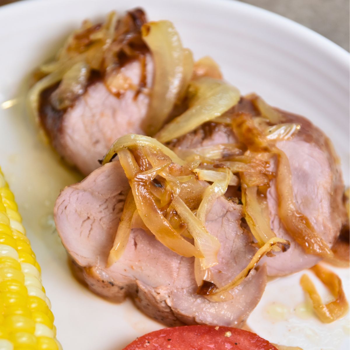 moist-pork-tenderloin-on-a-white-plate Pork tenderloin with golden caramelized onions