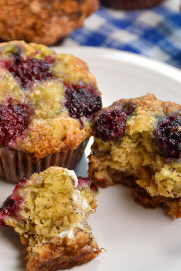 two blackberry banana muffins on white plate