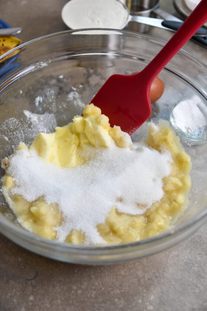 creaming butter sugar and smashed bananas in a clear bowl