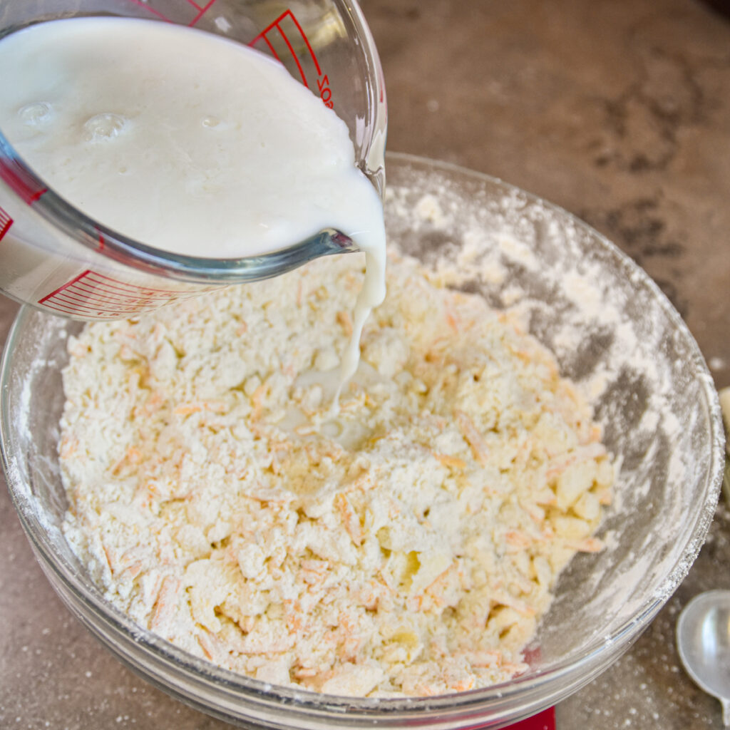 Adding buttermilk to biscuit mix.