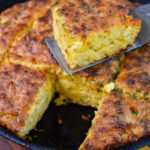 Serving one golden brown cheddar bay biscuit on a spatula.
