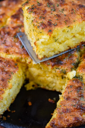 Serving one golden brown cheddar bay biscuit on a spatula.