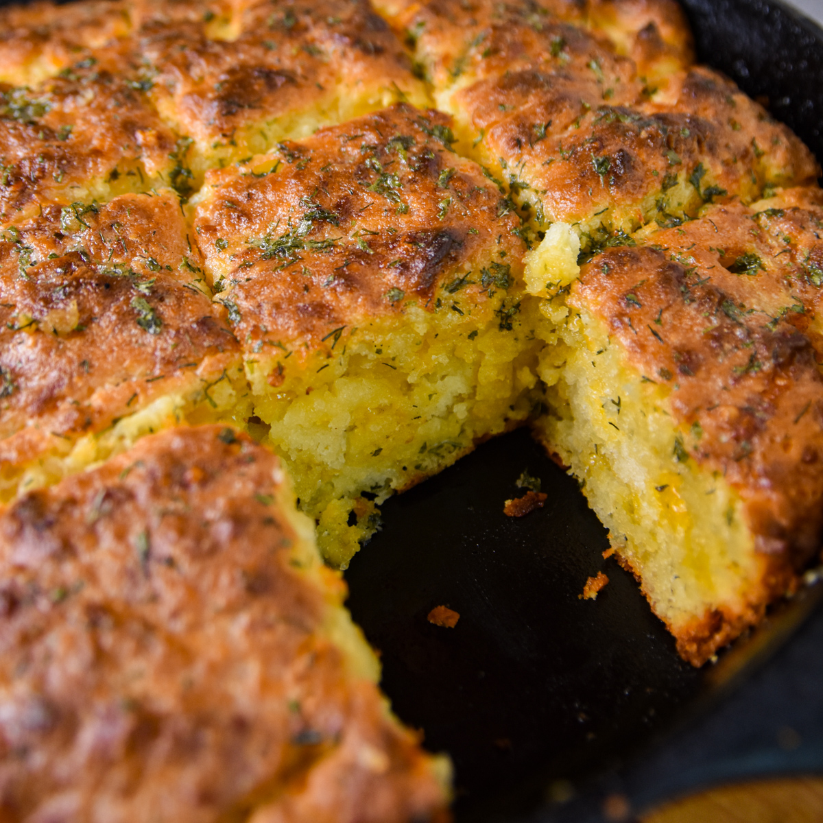 Iron skillet with golden brown homemade cheddar bay biscuits.