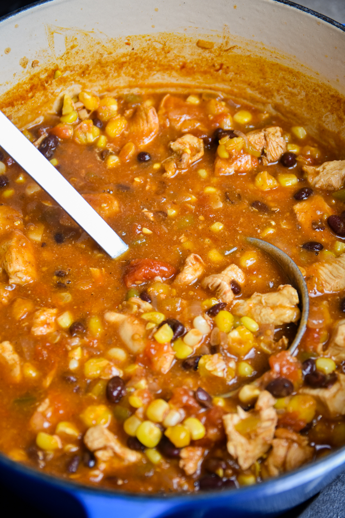 Finished enchilada soup in a dutch oven with ladle.