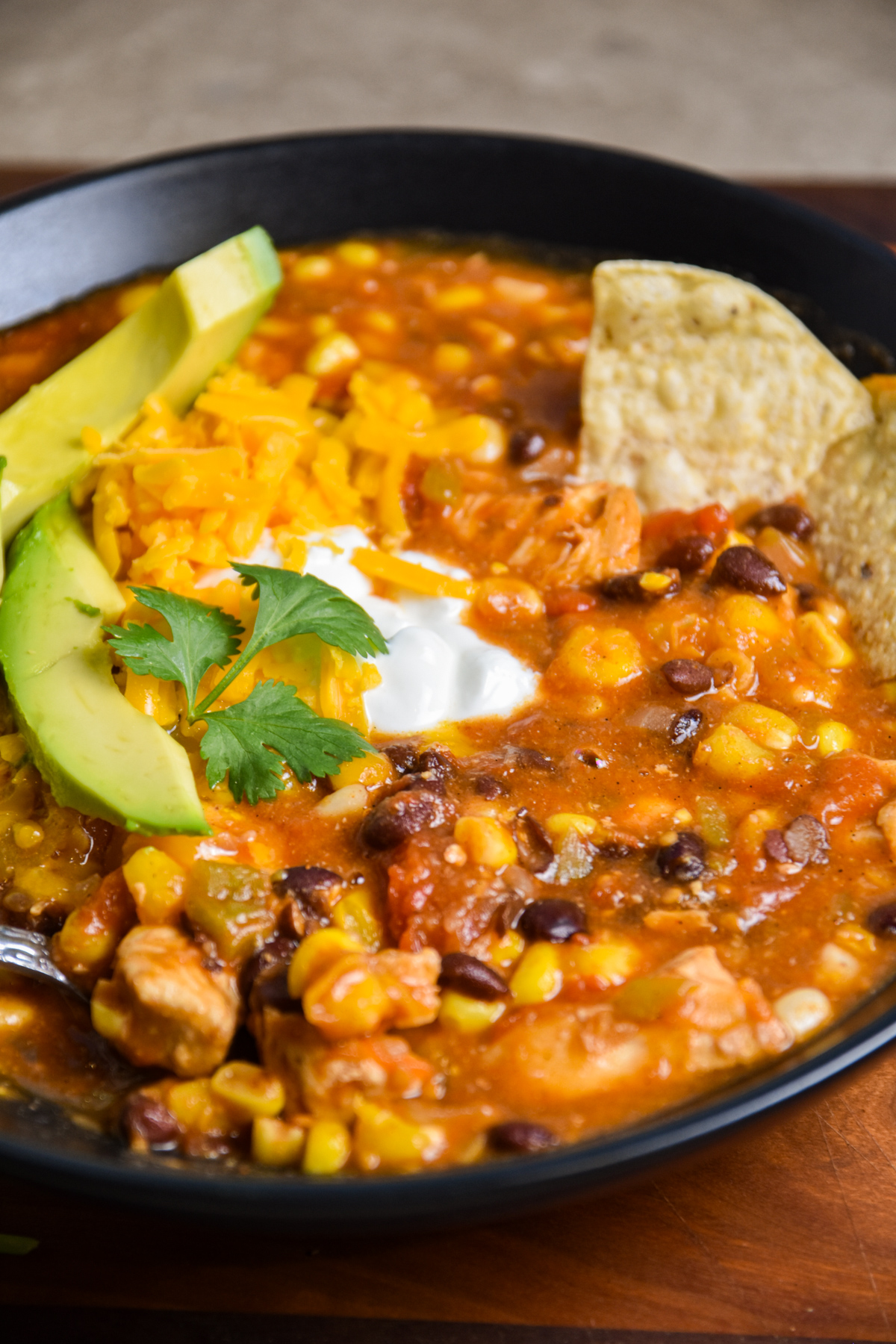 Bowl of enchilada soup with avocado.