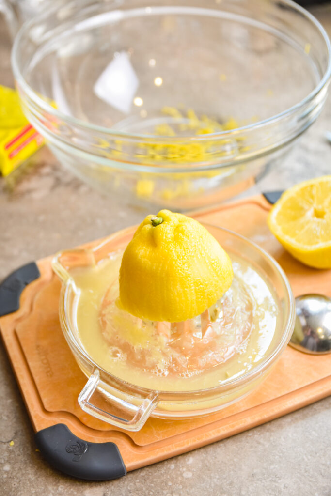 Juicing a lemon half for lemon jello cake.