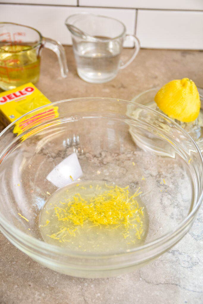 Lemon zest and juice in mixing bowl for lemon jello cake.