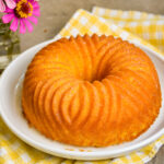 Iced lemon jello cake on white plate.