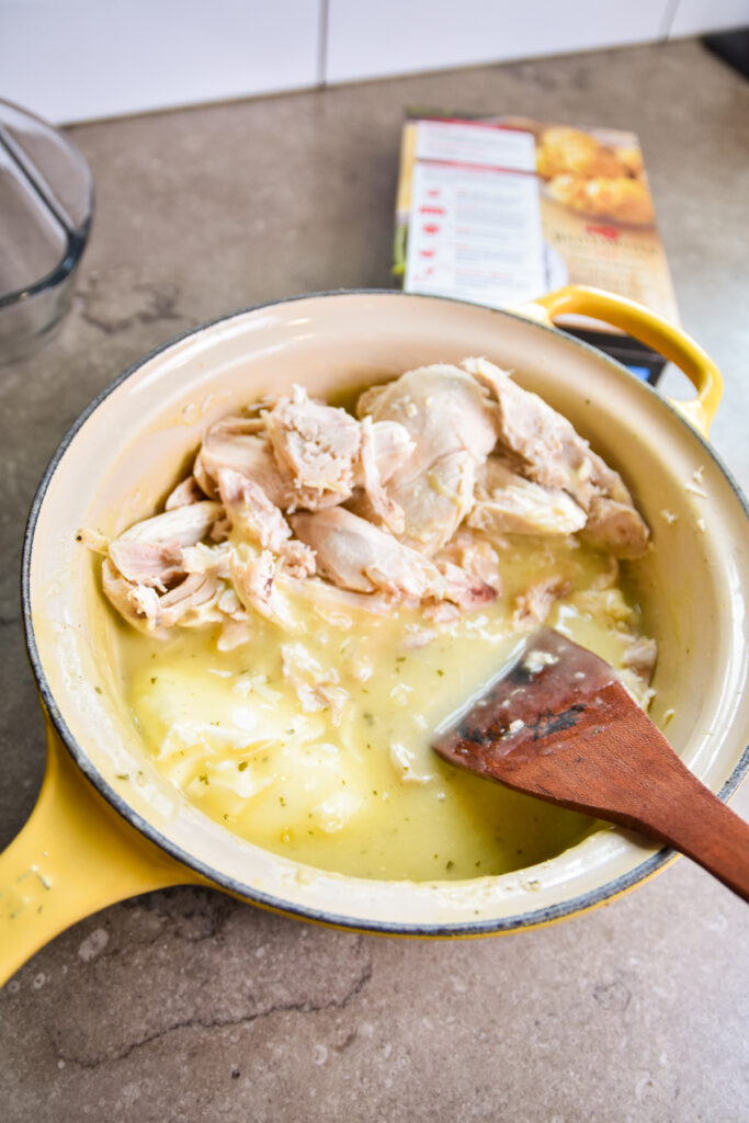 Adding chicken to chicken gravy for casserole.