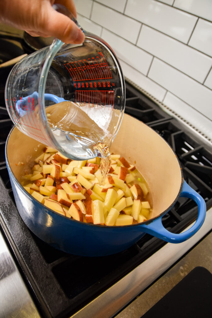 Adding water to potatoes to boil