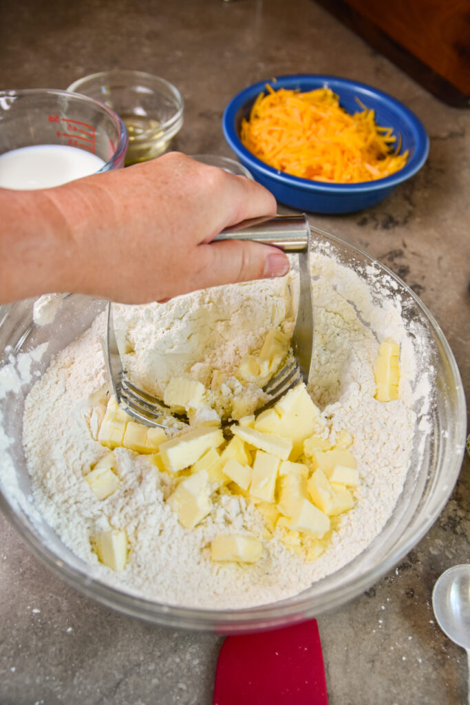 Cutting butter into cheddar bay biscuits.