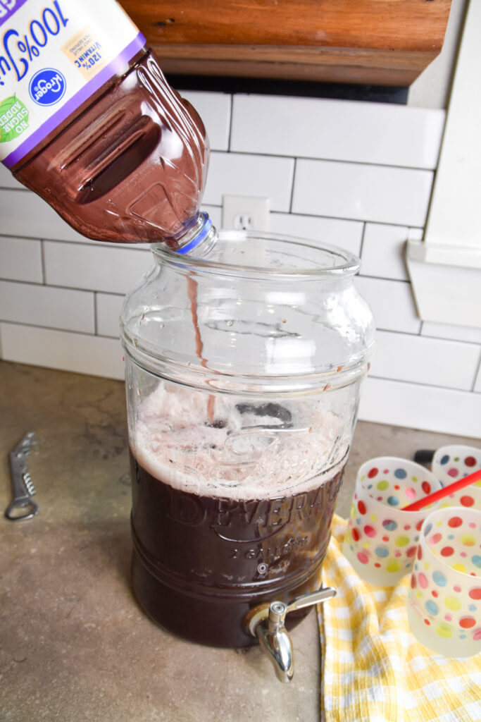 Pouring grape juice in purple party punch