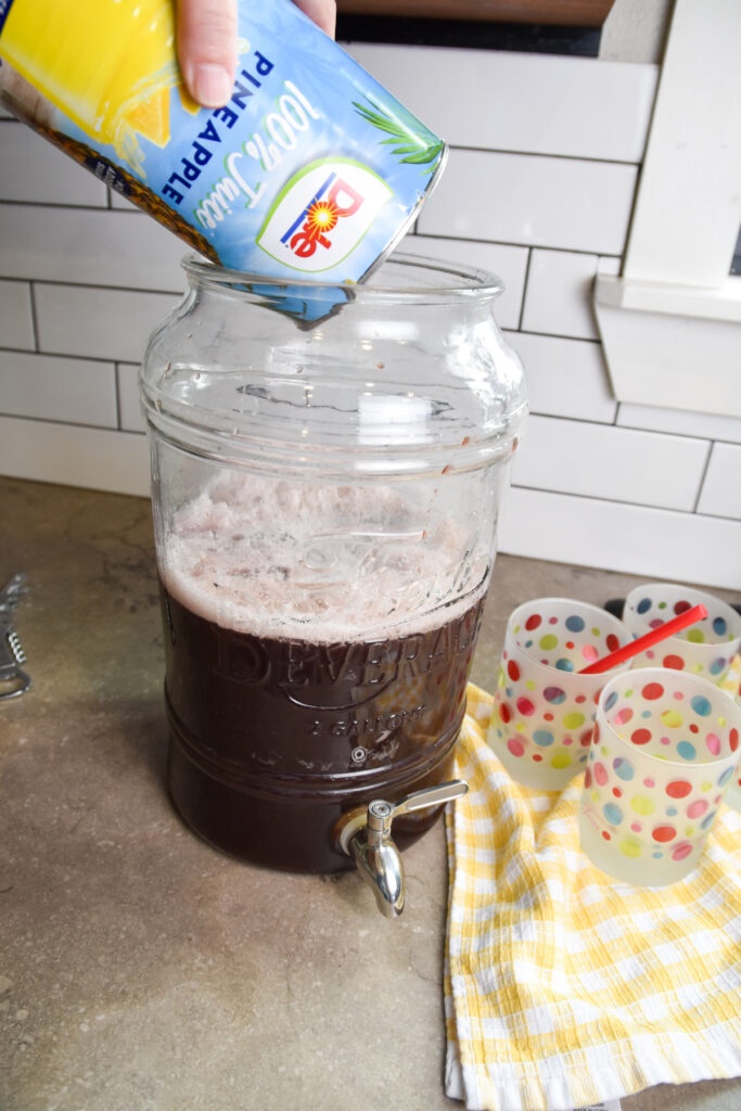 Adding pineapple juice to purple party punch