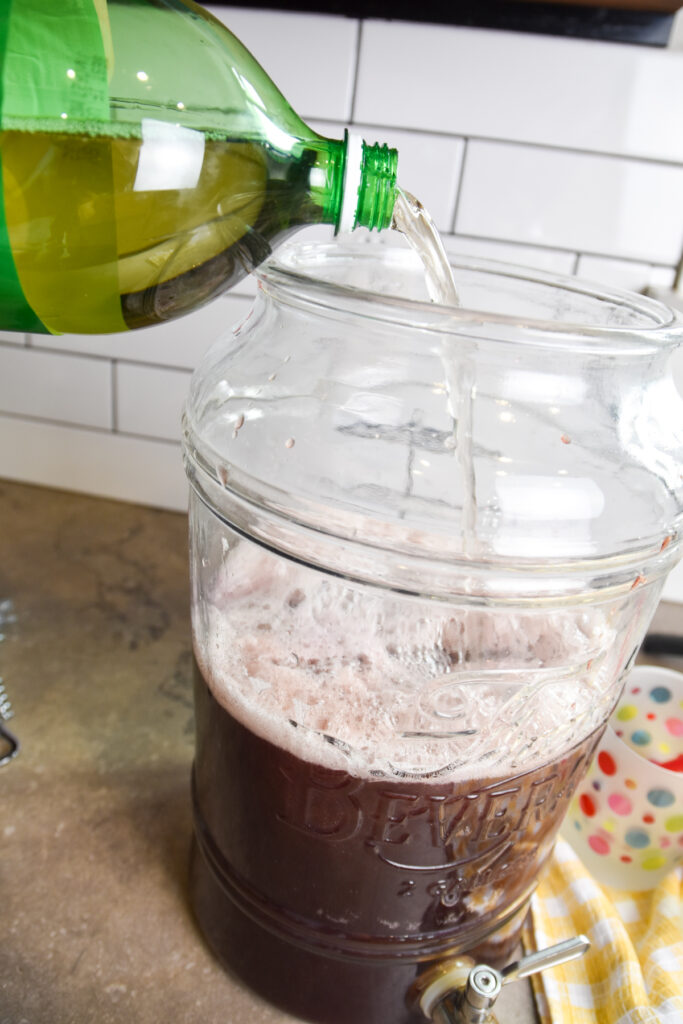 Adding ginger ale to purple party punch